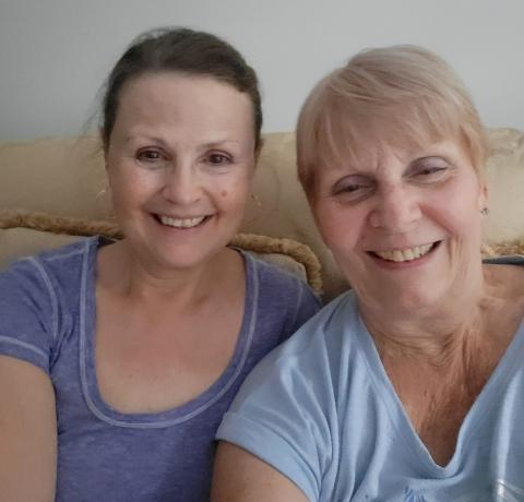 Two happy women sitting on a sofa