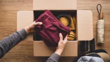 Photo of hands placing items in a cardboard box